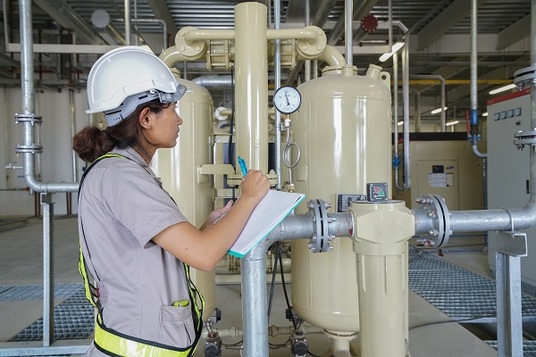 Technicienne travaillant sur un équipement frigorifique