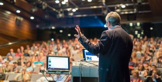 Homme s'adressant au public lors d'une conférence