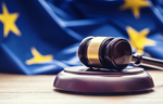 Judge's gavel in the foreground and European flag in the background